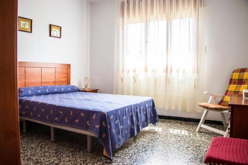 a bedroom with a blue bed and a window at Bungalows Pascual in Vinaròs