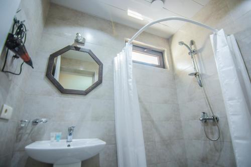 a bathroom with a sink and a shower with a mirror at Boutique Hotel BelleVue in Sighnaghi