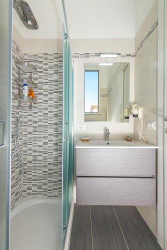 a white bathroom with a sink and a shower at Hotel Biagi & Residence in Lido di Camaiore