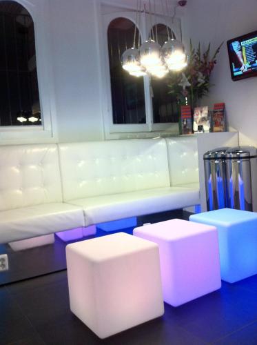 sala de estar con sofá blanco y 2 taburetes en Hotel Vossius Vondelpark, en Ámsterdam