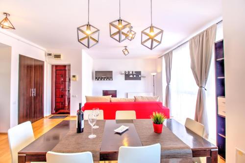 a living room with a table and a red couch at Europe Residence Central Apartment in Braşov