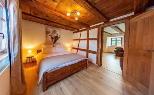a bedroom with a bed in a room with wooden ceilings at Le gîte des Histoires in Kientzheim
