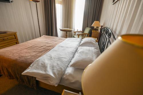 a bedroom with a bed with pillows on it at Hotel Kopala in Tbilisi City