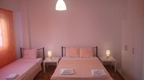 2 Betten in einem kleinen Zimmer mit 2 Lampen in der Unterkunft Bozena Apartment in Athen
