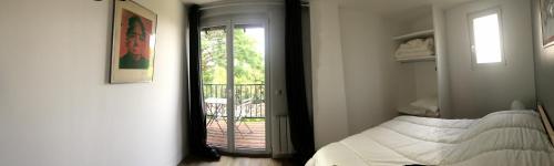 a bedroom with a mirror and a bed and a balcony at Les Terrasses De Chaumont 1 in Montsoreau