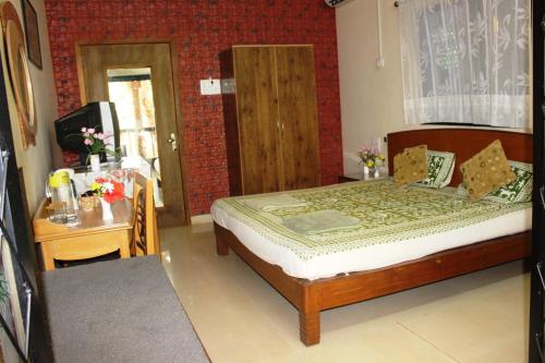 a bedroom with a bed and a table and a window at Mama Mids Home in Morjim