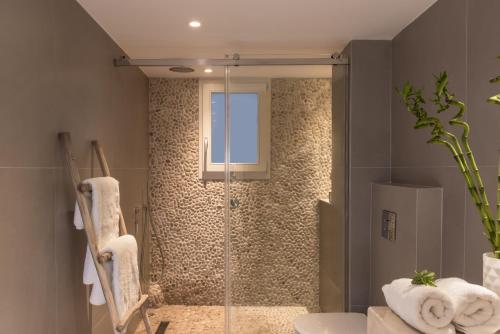 baño con ducha y puerta de cristal en White & Co. Exclusive Island Villas en Pyrgos