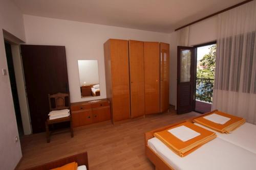 a bedroom with two beds and a dresser and a mirror at Apartments and rooms Porto in Ražanj