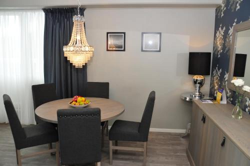 a dining room with a table and chairs and a chandelier at Best Western Leto Arena in Dal