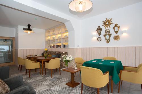 a restaurant with tables and chairs and a green table cloth at Hotel Marina in Port de Soller