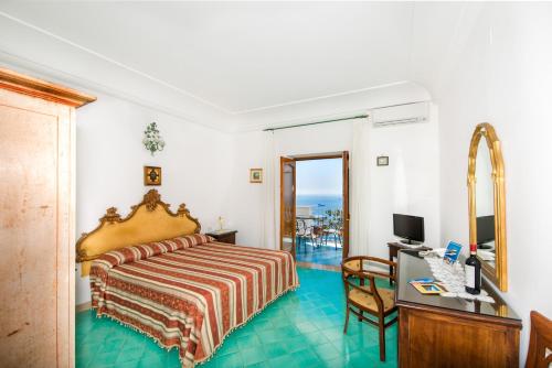 a hotel room with a bed and a desk and a computer at La Rosa Dei Venti in Positano