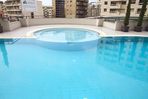 een groot blauw zwembad in een gebouw bij Promenade Hotel in Beiroet