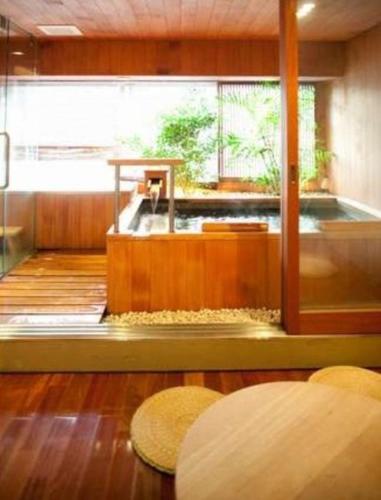 a room with a room with a tub in it at こんぴら温泉湯元八千代 in Kotohira