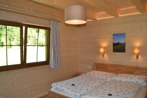 a bedroom with a bed and two windows at Ferienwohnung Hinterwinkl in Achenkirch