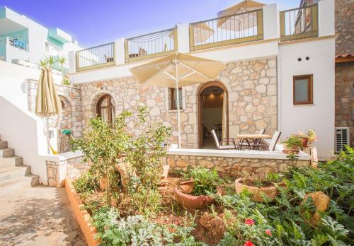 a house with a patio and an umbrella at Camelot Royal Beds by Estia in Malia