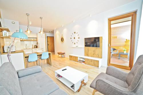 a living room with a couch and a table at Bursztynowa Apartments by Grand Apartments in Gdańsk