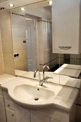 a bathroom with a sink and a mirror at Angel Apartment in Krynica Zdrój
