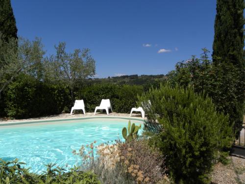 dos sillas blancas sentadas junto a una piscina en Casa di Campagna Maglianello, en Barberino di Val d'Elsa