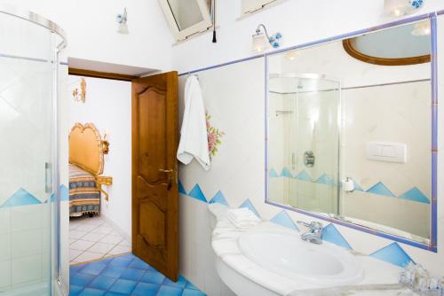 uma casa de banho com um lavatório e um espelho em La Rosa Dei Venti em Positano