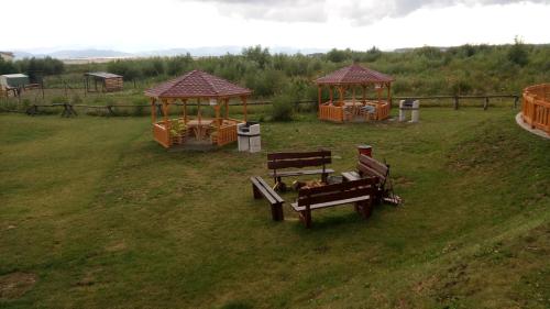 um grupo de bancos e gazebos num campo em Apartmán Fiona em Veľká Lomnica