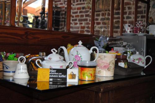 a counter top with a bunch of tea pots at B&B Het Loonderhof in Borgloon