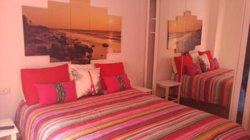 エル・メダノにあるBeach Apartmentのベッドルーム1室(ベッド1台付)が備わります。壁に絵が飾られています。