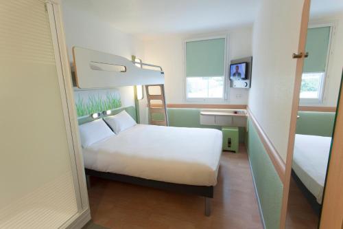 a hotel room with a bed and a bunk bed at ibis budget Cherbourg - La Glacerie in Cherbourg en Cotentin