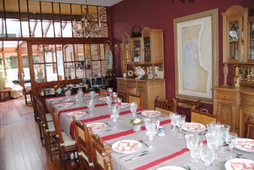 uma sala de jantar com uma mesa com pratos e copos em B&B Het Loonderhof em Borgloon