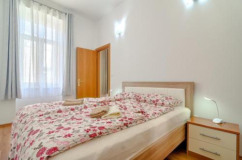 a bedroom with a bed with a floral bedspread at Apartment Zora & Natale in Pula