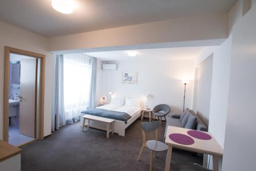 a hotel room with a bed and a table and chairs at Victoriei City Studios in Bucharest
