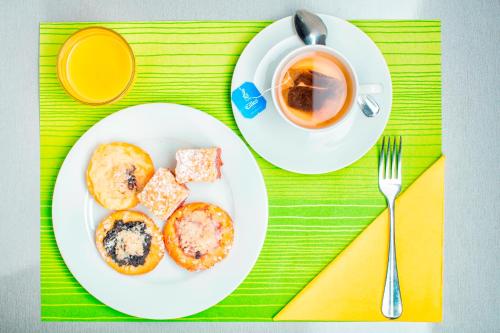 a white plate of food and a cup of coffee at Hotel Clement in Prague