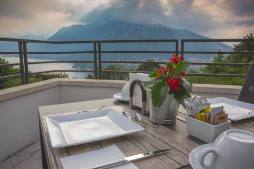 a table with a plate and a vase of flowers on a balcony at B&B Vista Lago in Como