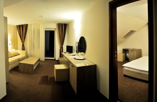 a hotel room with a bedroom with a bed and a mirror at Pensiunea Orizont in Poiana Brasov