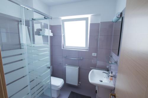 a bathroom with a sink and a toilet and a window at Victoriei City Studios in Bucharest