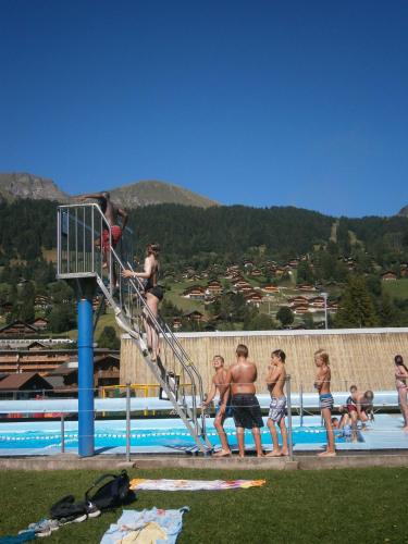 a group of people standing around a swimming pool at Le Sapin in Les Diablerets