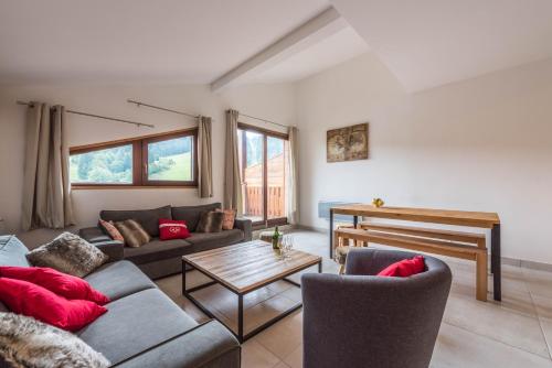 a living room with a couch and a table at Les Terrasses De Perrières in Les Gets