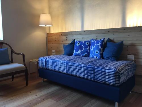a bedroom with a bed with blue pillows and a chair at Agriturismo Corte Bertesina in Vicenza