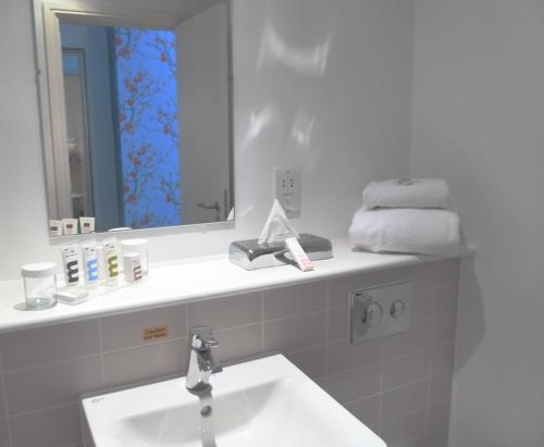 a white bathroom with a sink and a mirror at Mercure Darlington King's Hotel in Darlington