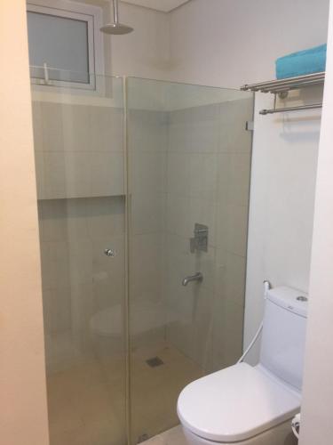 a bathroom with a glass shower with a toilet at ADC Condo 1 Bedroom Unit at Pico de Loro in Nasugbu