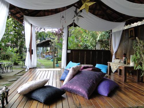 a bedroom with pillows on a wooden deck at Pousada Caúca in Abraão