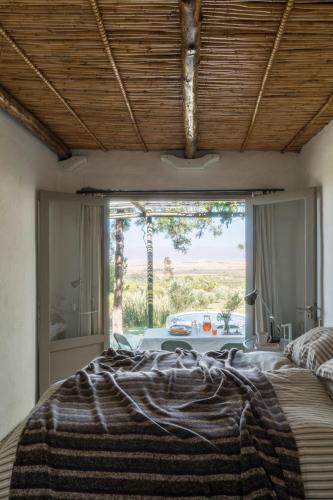 a bedroom with a bed with a large window at Kleinkloof Farm in Piketberg