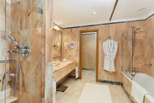 a bathroom with a tub and a sink and a shower at Hotel Quinta do Lago in Quinta do Lago