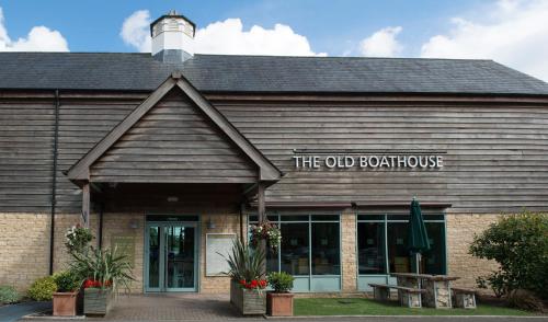 a building with a sign that reads the old boat house at De Vere Cotswold Water Park in Cirencester