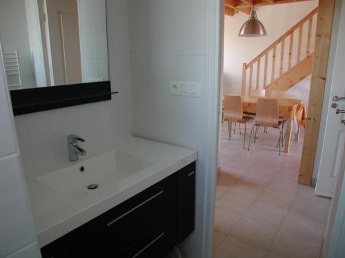 ein Badezimmer mit Waschbecken und einem Tisch mit Stühlen in der Unterkunft Roches Blanches 3 in Saint-Lunaire
