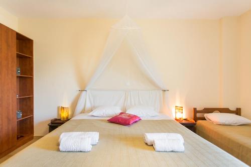 a bedroom with a large bed with two towels on it at Marathon Beachside Villa 100m from the beach in Schinias
