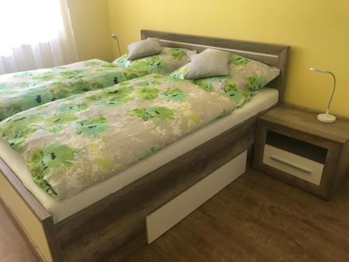 una camera con letto e piumone verde di Apartman illy a Veľký Slavkov