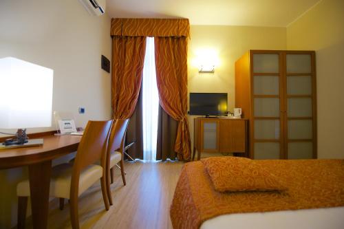 a bedroom with a desk and a bed and a table at Best Western Crystal Palace Hotel in Turin