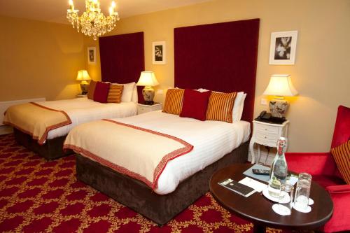 a hotel room with two beds and a couch at Ballyseede Castle in Tralee