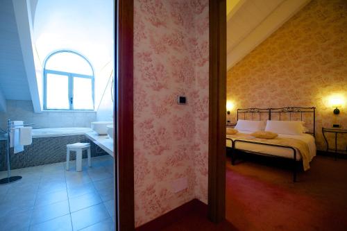 a bedroom with a bed and a bathroom with a tub at Best Western Crystal Palace Hotel in Turin