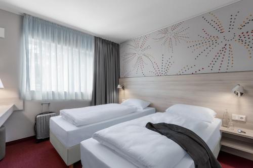 Postel nebo postele na pokoji v ubytování Serways Hotel Steigerwald